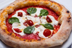 Wood-fired margarita pizza with ricotta, cherry tomatoes and basil